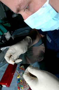 US Navy 061118-N-2659P-032 U.S. Navy Hospital Corpsman Roger Seebach inspects tools while preparing for routine dental treatments aboard the nuclear-powered aircraft carrier USS John C. Stennis (CVN 74)