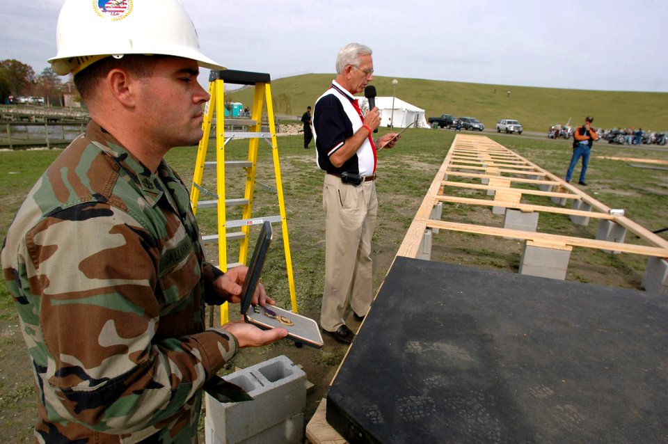 US Navy 061115-N-4515N-341 Chief Builder Hugh Callahan assigned to Seabee Construction Battalion Maintenance Unit Two Zero Two (CBMU-202), holds the Purple Heart as Meyer Davis, general manager of Kellum funeral home, recites t