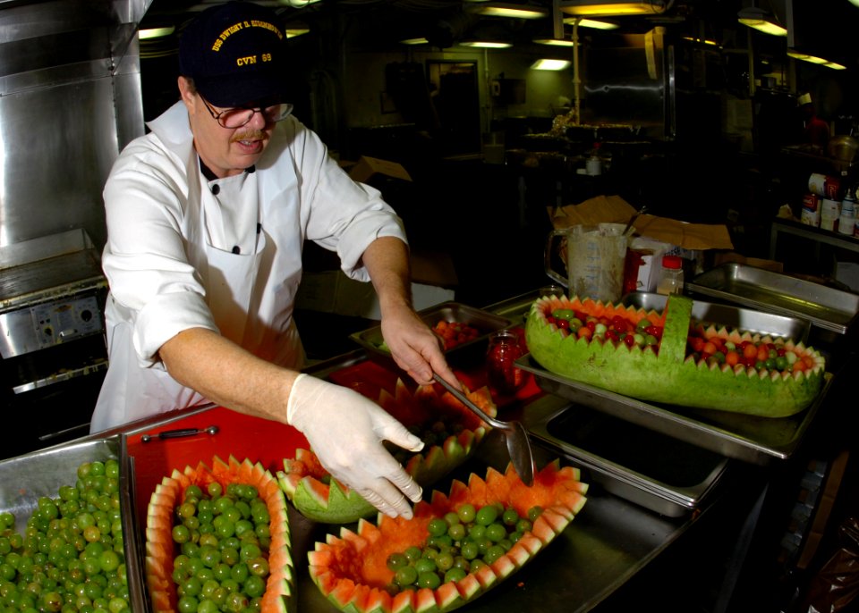 US Navy 061123-N-8907D-004 Chef instructor Denzel McCoy adds grapes to his fruit platter for a Thanksgiving feast aboard Nimitz-class aircraft carrier USS Dwight D. Eisenhower (CVN 69)