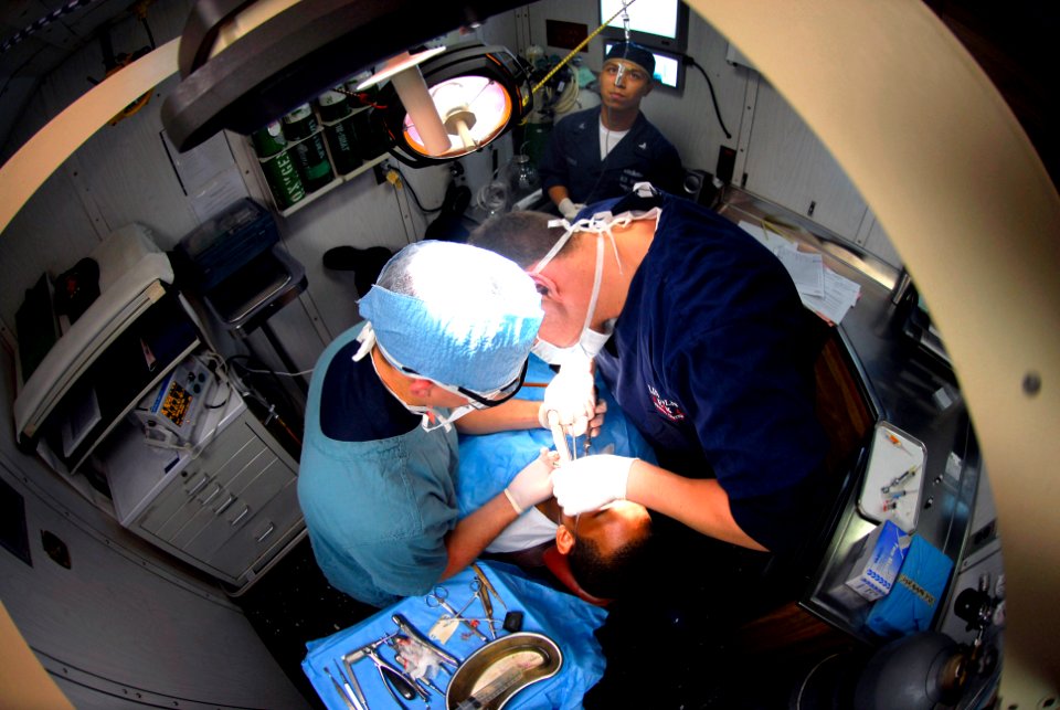 US Navy 061117-N-6106R-025 Lt. Steve Manzon, from New York City, stitches an oral incision closed on a patient while Hospitalman Alex Johnson, from Jackson, Mississippi, assists