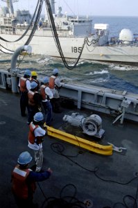 US Navy 061117-N-8148A-113 U.S. Navy line handlers aboard the Military Sealift Command (MSC) fast combat support ship USNS Supply (T-AOE 6) stabilize a communication line during an underway replenishment