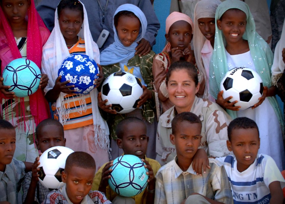 US Navy 061119-N-1328C-109 Lt. Cmdr. Wendy Halsey from Honolulu, Hawaii, poses with children from a local school in Balbala, Djibouti, after donating soccer balls to the schoolchildren