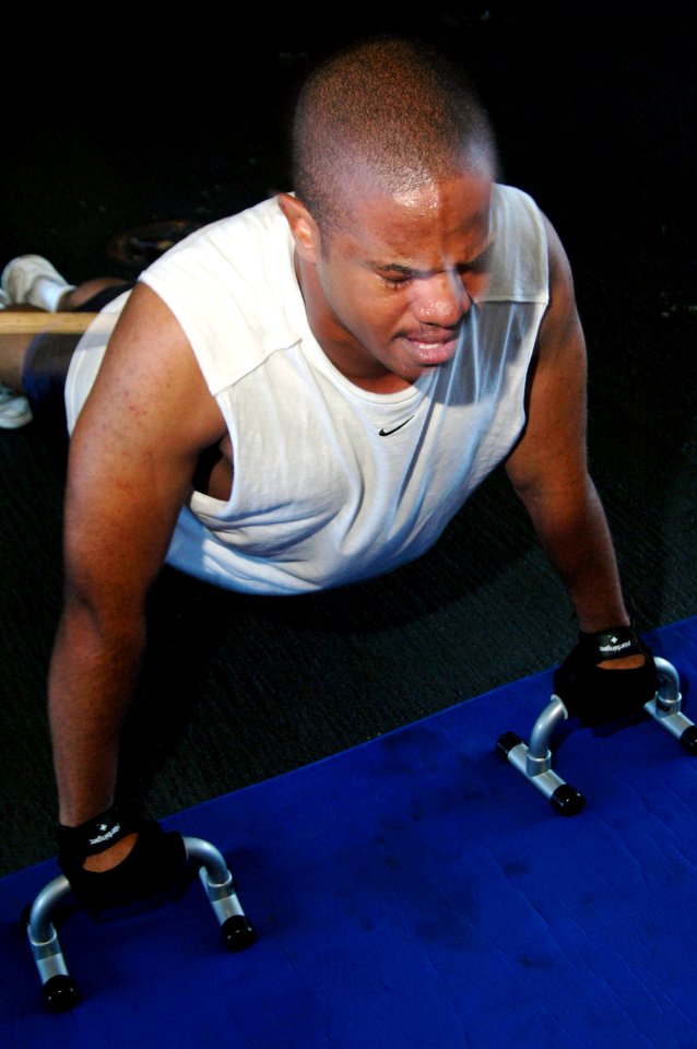 US Navy 061121-N-5387K-082 Mass Communication Specialist Seaman Matthew Patton, 21, of Oakland, Calif., performs raised pushups during a fitness enhancement program (FEP) workout in the hangar bay of USS Kitty Hawk (CV 63)