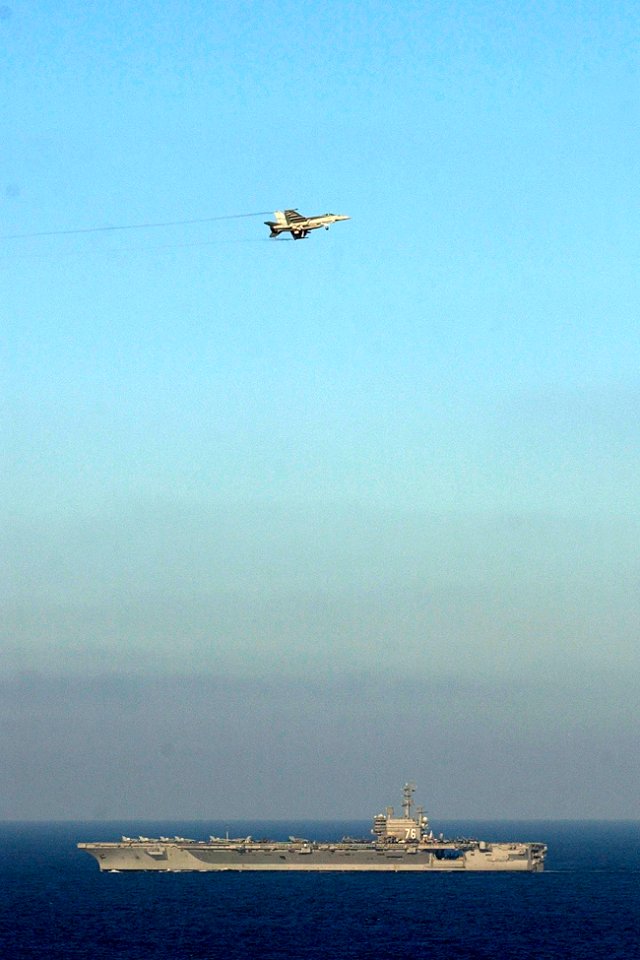 US Navy 061115-N-7130B-187 In the skies above USS Ronald Reagan (CVN 76), an F-A-18E Super Hornet circles the approach pattern to make an arrested landing aboard the ship