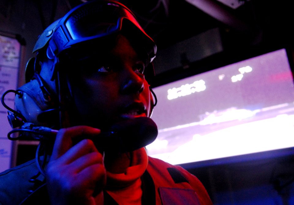 US Navy 061116-N-4776G-036 Aviations Boatswain's Mate Airman Kenyata Salas relays a message to hangar deck control aboard USS Ronald Reagan (CVN 76)