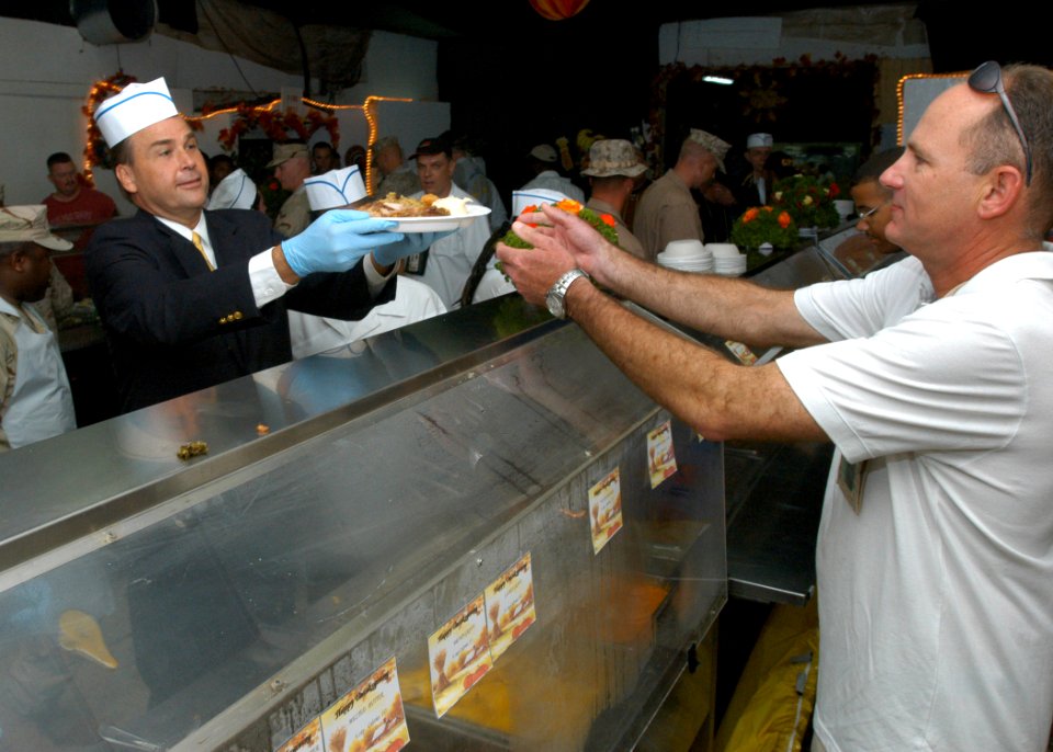 US Navy 061123-N-1328C-124 U.S. Ambassador to Djibouti W. Stuart Symington, left, assists in serving Thanksgiving dinner to U.S. service members of Combined Joint Task Force - Horn of Africa at the Bob Hope Dining Facility on b