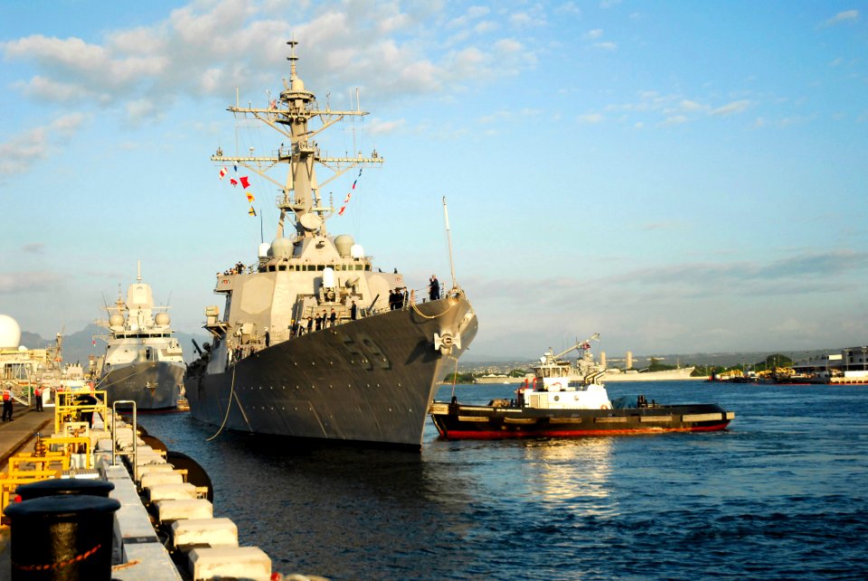 US Navy 061201-N-4774B-001 A tugboat assigned to Naval Station Pearl Harbor guides Arleigh Burke-class guided-missile destroyer USS Russell (DDG 59) to the pier as she returns to its homeport