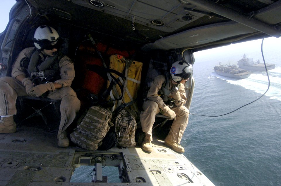 US Navy 061122-N-8148A-153 U.S. Navy Aviation Warfare Systems Operators 3rd Class Jonathan DeJesus, left, and Christopher Adams, watch the Military Sealift Command (MSC) fast combat support ship USNS Supply (T-AOE 6)