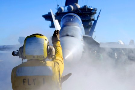US Navy 061201-N-8158F-147 viation Boatswain's Mate Handler Airman Sherard Bell directs an F-A-18 Hornet to catapult one prior to launch cycles on the flight deck aboard the nuclear-powered aircraft carrier USS Nimitz (CV