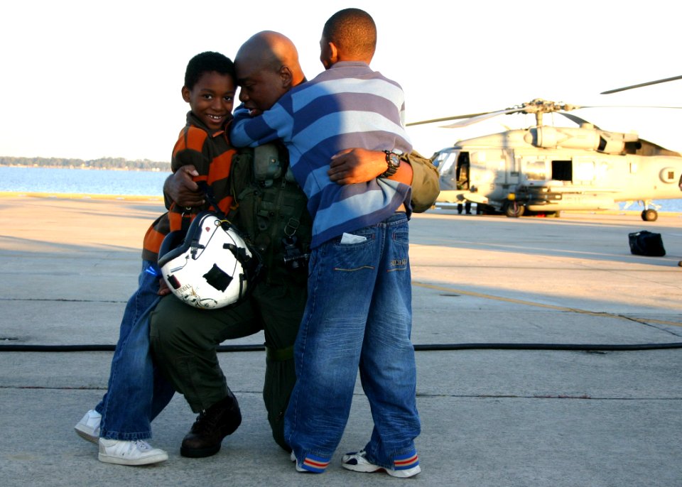 US Navy 061117-N-8544C-045 Lt. Michael Jackson embraces his sons on the pier during the homecoming of Helicopter Antisubmarine Squadron One One (HS-11)
