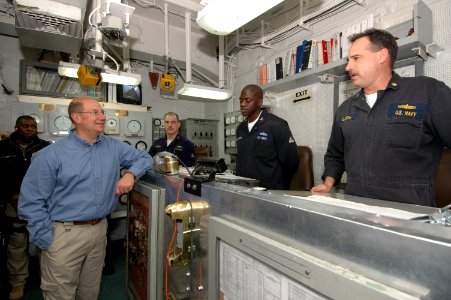 US Navy 061124-N-0209M-006 Secretary of the Navy (SECNAV) The Honorable Donald C. Winter listens as chief engineer Cmdr. James Dykema explains the ship's propulsion systems during a visit to amphibious assault ship USS Boxer (L