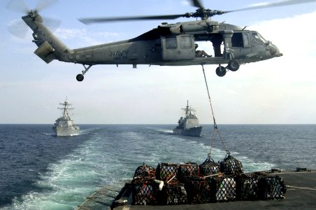 US Navy 061120-N-8148A-014 A MH-60S Seahawk helicopter assigned to the Dragon Whalers of Helicopter Sea Combat Squadron Two Eight (HSC-28), lifts supplies from the stern of the Military Sealift Command (MSC) fast combat support