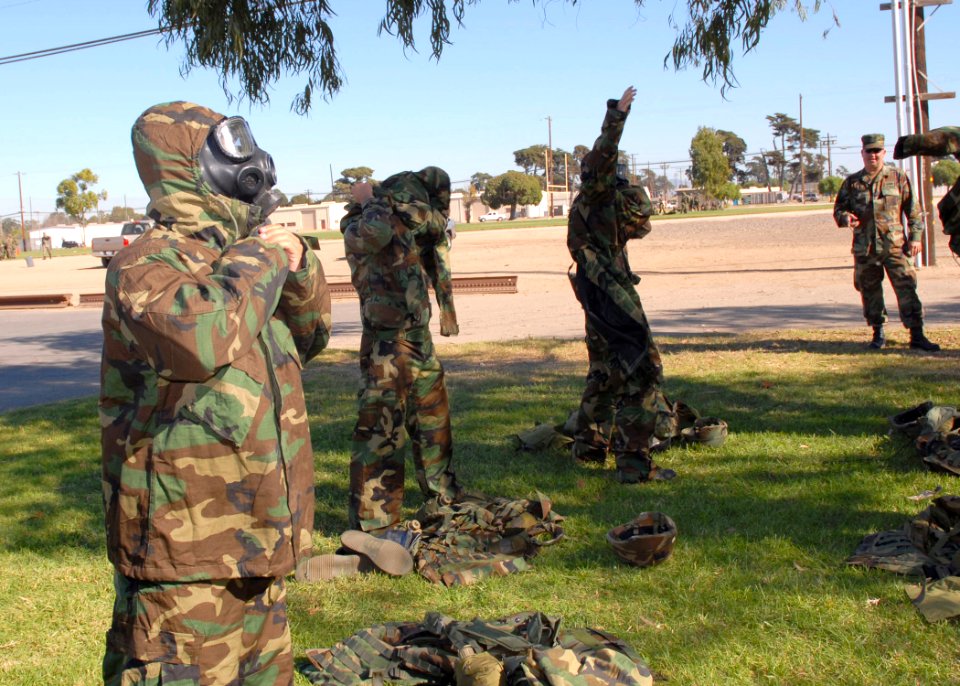 US Navy 061123-N-3560G-012 Members of Naval Mobile Construction Battalion Four (NMCB-4) don chemical protective suits in a timed event during a Super Squad training competition