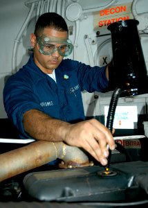 US Navy 061130-N-2636M-004 Aviation Support Equipment Technician Airman William Quinonez changes the oil in a forklift during regular maintenance planned maintenance system (PMS) on board amphibious assault ship USS Bataan (LHD