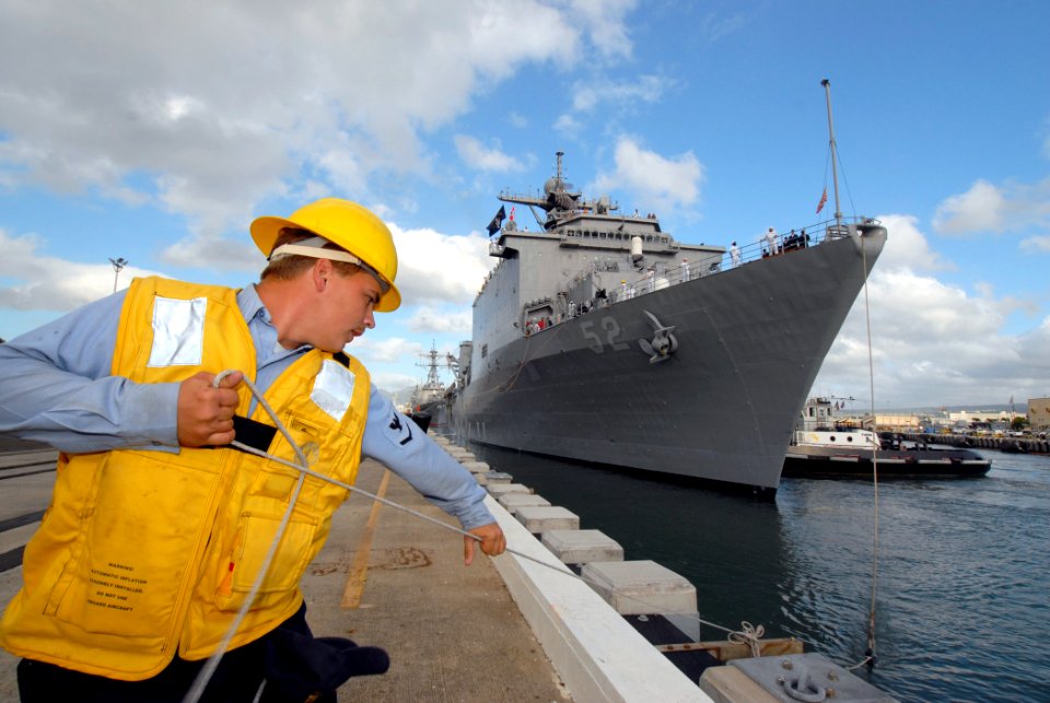 US Navy 061204-N-4965F-010 Boatswain's Mate 3rd Class Jeremy Criss heaves in a mooring line