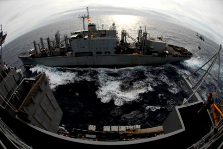 US Navy 061130-N-8591H-051 Sailors on board USS Kitty Hawk (CV 63) watch as an MH-60S Seahawk from Helicopter Sea Combat Squadron Two Five (HCS-25) transfers supplies over from the Military Sealift Command (MSC) combat stores s