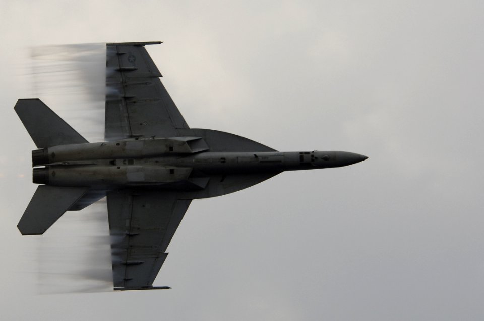 US Navy 061204-N-8591H-290 An F-A-18F Super Hornet assigned to the Strike Fighter Squadron One Zero Two (VFA-102) speeds up for a supersonic fly-by as part of an air power demonstration aboard USS Kitty Hawk (CV 63)