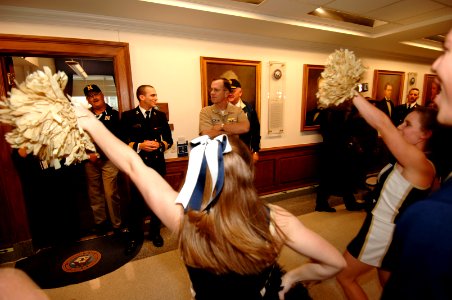 US Navy 061130-N-3642E-106 Chief of Naval Operations (CNO) Adm. Mike Mullen looks on as the U.S. Naval Academy Cheerleaders perform during a pep rally at the Pentagon prior to the upcoming Army-Navy game