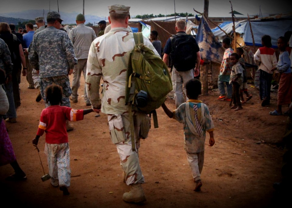 US Navy 061202-F-4925S-052 U.S. Navy Lt. Cmdr. Jeff Weitz walks holding hands with two children who live in a tent city set up by Combined Joint Task Force-Horn of Africa (CJTF-HOA) after a severe flooding in Dire Dawa, Ethiopi