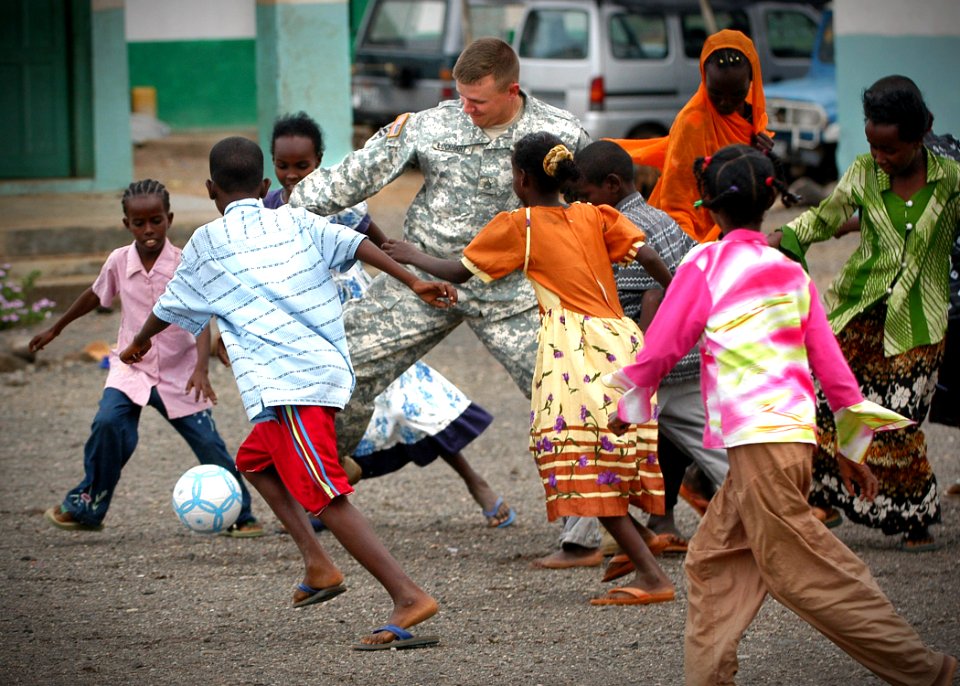 US Navy 061202-N-1328C-114 U.S. Army Staff Sgt. Justin Lockhart, attached to Bravo Co., 489th, Civil Action Battalion, participates in a game of soccer with students from the Djibouti City School