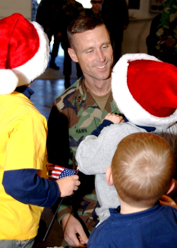 US Navy 061205-N-XXXXW-003 Naval Mobile Construction Battalion One (NMCB-1), Executive Officer, Lt. Cmdr. Eric J. Hawn, greets his three children after returning from the battalion's six-month deployment to the Far East
