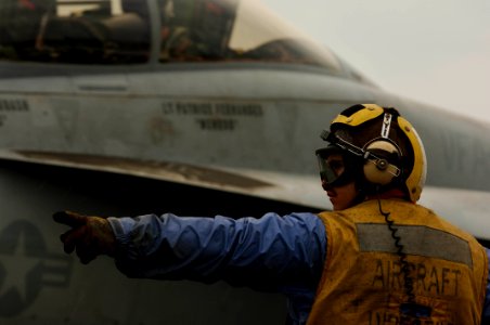 US Navy 061202-N-8591H-049 Aviation Boatswain's Mate Airman Ricky Silvers directs an F-A-18F Super Hornet assigned to Strike Fighter Squadron One Zero Two (VFA-102) after the aircraft landed on board USS Kitty Hawk (CV 63).