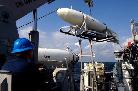 US Navy 061202-N-5555T-018 A USS Ardent (MCM 12) mineman moves a Type 1 float that is used to conduct mechanical mine sweeping prior to a mine countermeasure exercise