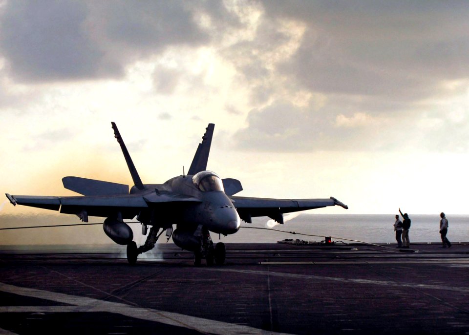 US Navy 061129-N-8591H-268 Landing signal officers watch as an F-A-18C Hornet assigned to the Golden Dragons of Strike Fighter Squadron One Nine Two (VFA-192) lands on the flight deck of USS Kitty Hawk (CV 63)