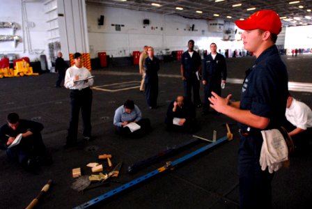 US Navy 061202-N-4133B-005 Damage Controlman 3rd Class Christopher Conrad from Goodhue, Minn., instructs Sailors on how to use shoring in the hangar bay aboard USS Ronald Reagan (CVN 76)