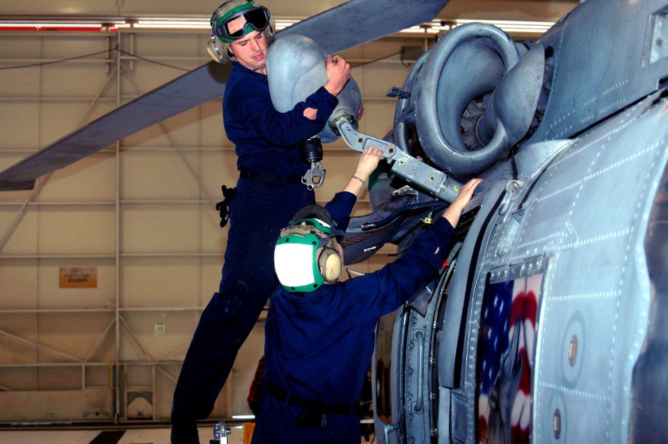 US Navy 061128-N-1226D-044 Aviation Structural Mechanic 3rd Class Amanda Fields and Airman Jared Muise of Helicopter Anti-submarine Squadron Light Four Five (HSL-45) install a rescue hoist on an SH-60 Seahawk