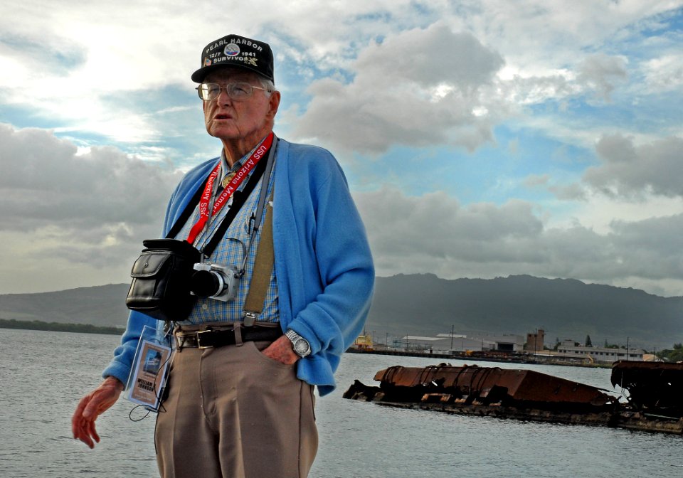 US Navy 061203-N-4774B-016 Pearl Harbor survivor William Bob Johnson explains his location and the role he played on Ford Island during the 1941 attack on Pearl Harbor with the USS Utah Memorial in the background