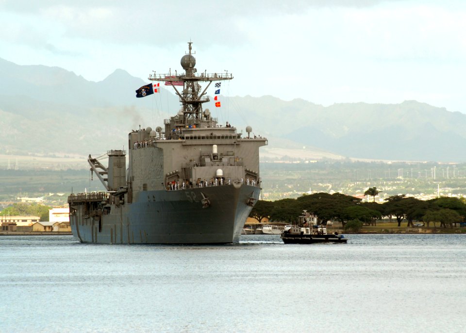 US Navy 061204-N-4965F-003 Sailors aboard dock landing ship USS Pearl Harbor (LSD 52) man the rails as a tugboat assigned to Naval Station Pearl Harbor guides the ship into Pearl Harbor