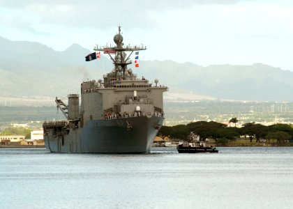 US Navy 061204-N-4965F-003 Sailors aboard dock landing ship USS Pearl Harbor (LSD 52) man the rails as a tugboat assigned to Naval Station Pearl Harbor guides the ship into Pearl Harbor