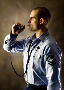 US Navy 061204-N-9446C-001 A portrait of Boatswain's Mate 2nd Class Kevin Diebold, assigned to deck department, aboard the Nimitz-Class aircraft carrier USS Carl Vinson (CVN 70) holding his Boatswain's Pipe