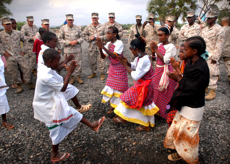 US Navy 061205-N-1328C-530 U.S. Marines assigned to the 5th Provisional Security Company watch a dance performed by students of the Douda Primary School