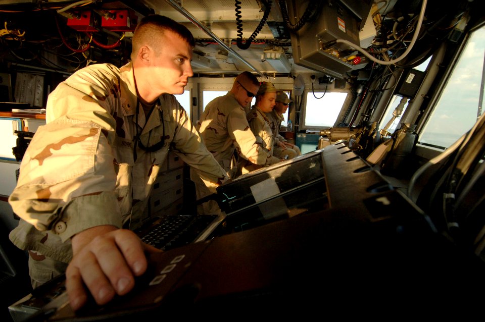US Navy 061205-N-8148A-035 Officer of the deck, Boatswain's Mate 2nd Class Jason Burke, of Tampa, Fla., scans for surface contacts from the bridge to ensure the ship's safety at sea