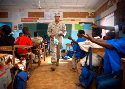 US Navy 061205-N-1328C-419 U.S. Marine Corps Lance Cpl. Jesus Hernandez, from Amarillo, Texas, and other marines from the 5th Provisional Security Company, hand out school supplies