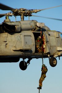 US Navy 061205-N-8158F-027 Explosive Ordnance Disposal (EOD) Technician 1st Class Scott Harstad, assigned to Explosive Ordnance Disposal Mobile Unit One One (EODMU-11), Detachment Northwest, fast ropes from an SH-60 Seahawk