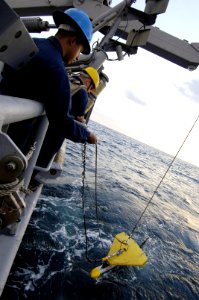 US Navy 061205-N-5555T-007 A U.S. Navy minemen guides a Kline Sonar machine, used for ocean floor surveying and detection of mine-like objects, over the side of USS Ardent (MCM 12) during a mine countermeasure exercise