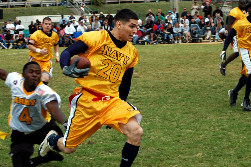US Navy 061203-N-3957R-006 Navy wide receiver Yeoman 3rd Class Jesse Robles assigned to Naval Mobile Construction Battalion One (NMCB-1) breaks away from an Army defender
