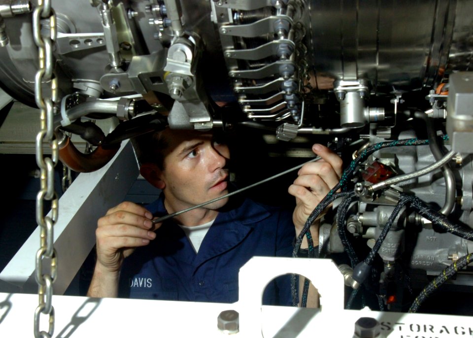 US Navy 061201-N-8907D-004 Aviation Machinist's Mate Airman Shane Davis performs maintenance on a jet engine aboard the Nimitz-class aircraft carrier USS Dwight D. Eisenhower (CVN 69)