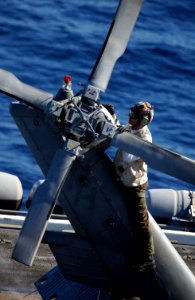 US Navy 061202-N-0890S-037 A crew member assigned to the Helicopter Anti-Submarine Squadron Six (HS-6) inspects an SH-60F Seahawk before flight operations on the flight deck aboard the nuclear-powered aircraft carrier USS Nimit