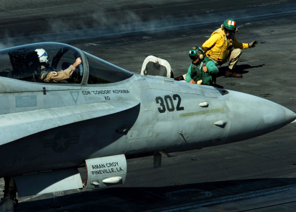 US Navy 061206-N-8907D-007 A flight deck director gives the signal to launch an F-A-18C Hornet assigned to the