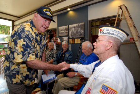 US Navy 061206-N-4965F-006 USS Oklahoma survivor, Jerry Tessaro, shakes hands with fellow USS Oklahoma survivor, Raymond Richmond, during the Pearl Harbor Naval Shipyard, USS Oklahoma Lobby Display Dedication ceremony on board