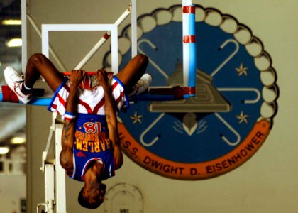 US Navy 061212-N-5330L-016 Jermaine Brown, a member of the Harlem Globetrotters, hangs around after a slam-dunk near the end of the Globetrotters' game against the New York Nationals aboard Nimitz-class aircraft carrier USS Dwi