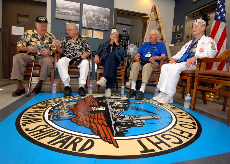 US Navy 061206-N-4965F-007 USS Oklahoma survivors, Ray Turpin, Jerry Tessaro, Paul Goodyear, George Smith and Raymond Richmond sit at the crest of the Pearl Harbor Naval Shipyard logo