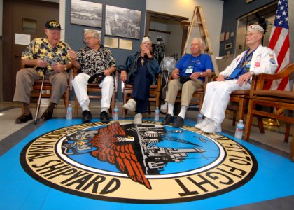 US Navy 061206-N-4965F-007 USS Oklahoma survivors, Ray Turpin, Jerry Tessaro, Paul Goodyear, George Smith and Raymond Richmond sit at the crest of the Pearl Harbor Naval Shipyard logo
