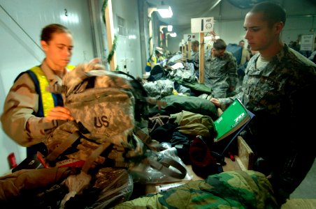 US Navy 061212-N-8148A-019 A soldier assigned to Army 82nd Airborne Division stands by and observes as his personal belongings are searched and inspected by Customs Border Clearance Agent Mass Communication Specialist 3rd Class