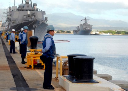 US Navy 061204-N-4965F-001 Sailors assigned to Arleigh-Burke class guided-missile destroyer USS Russell (DDG 59) wait pierside Naval Station Pearl Harbor to perform line handling duties for dock landing ship USS Pearl Harbor (L