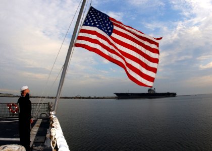 US Navy 061207-N-1810F-009 Service member assigned to USS Farragut (DDG 99) salutes the Ensign in memory of those fallen shipmates lost during the 1941 attack on Pearl Harbor